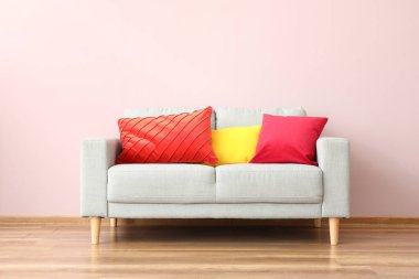 Renkli duvarın yanındaki yastıklı modern kanepe.