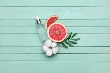 Greyfurt, pamuk çiçeği ve ahşap arka planda gerekli yağı içeren kompozisyon