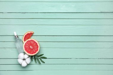 Greyfurt, pamuk çiçeği ve ahşap arka planda gerekli yağı içeren kompozisyon