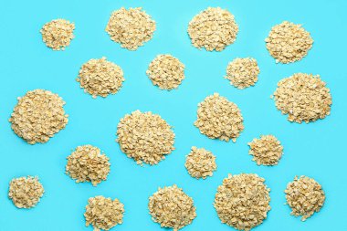 Mavi arka planda bir yığın çiğ yulaf ezmesi.