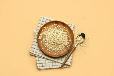 Arkaplanda çiğ yulaf ezmesi olan tabak ve kaşık