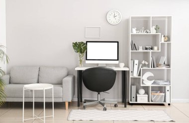 Çalışma odası, raf ünitesi ve kanepesi olan bir ofis.