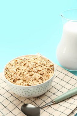 Arka planda bir kase çiğ yulaf ezmesi ve kaşık