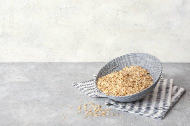 Hasır kase dolusu çiğ yulaf ezmesi.