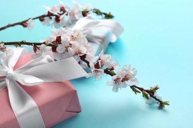 Güzel açan bahar dalları ve mavi arka planda hediyeler