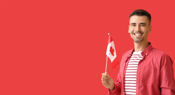 Kırmızı Arka Planda Kanada Bayrağını Tutan Genç Bir Adam — Stok fotoğraf