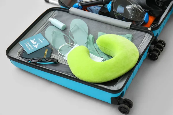 Plaj aksesuarlı bavul ve arka planda bağışıklık pasaportu.