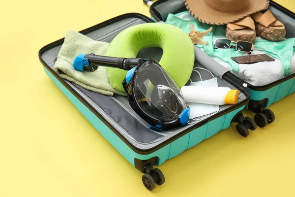 Kadın plaj aksesuarları ve sarı arka planda şnorkelli maske.