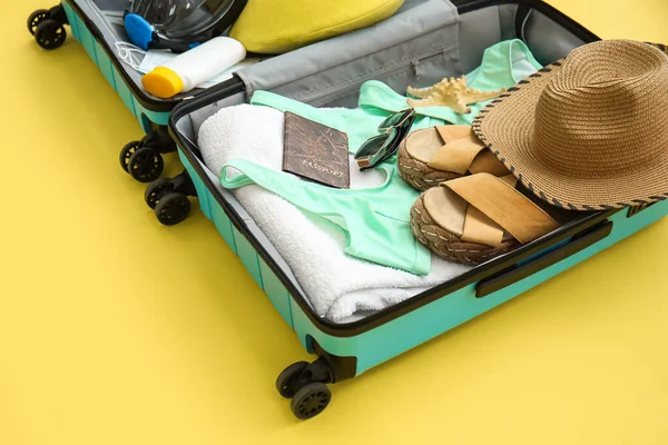 Kadın plaj aksesuarları ve sarı arka planda şnorkelli maske.