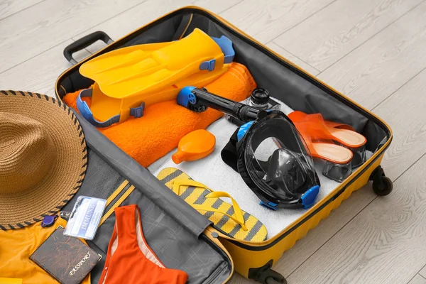 Kadın plaj aksesuarları, bağışıklık sertifikası ve beyaz ahşap arka planda şnorkelli maske.