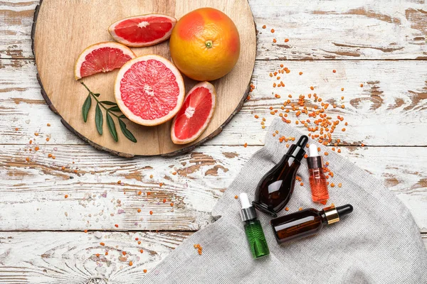 Greyfurtlu kompozisyon ve hafif ahşap arka planda gerekli yağ şişeleri