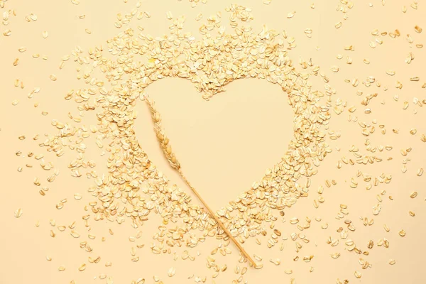 Renkli arka planda çiğ yulaf ezmesi ve dikenli dikenden yapılmış kalp.