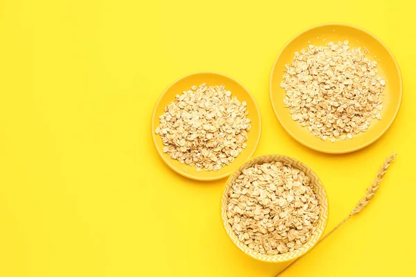 Sarı arka planda çiğ yulaf ezmesi tabakları