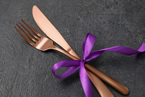 Koyu arkaplanda kurdeleli çatal ve bıçak