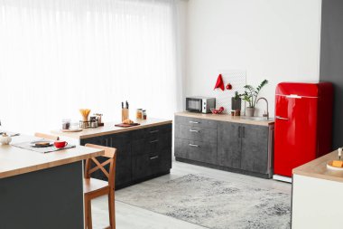 Kırmızı buzdolabı, tezgah ve tahta kaplı modern mutfak.