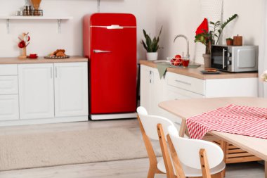 Açık mutfakta peçeteli ve sandalyeli yemek masası.