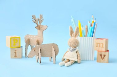 El yapımı karton oyuncaklar, sevimli tavşanlar ve renkli arka planda kırtasiye malzemeleri.