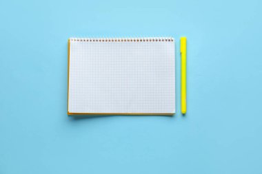 Açık mavi arkaplanda defter ve kalem