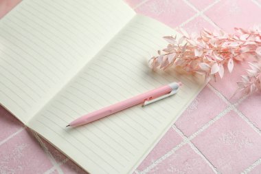 Pembe arka planda dizüstü bilgisayar ve kalem