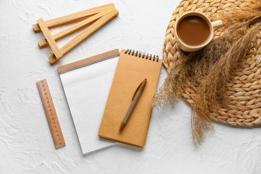 Not defterli kompozisyon, bir fincan kahve, cetvel ve beyaz arka planda kalem, üst görünüm