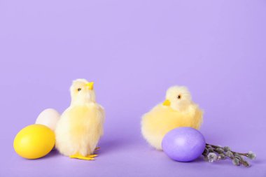 Cute chickens, pussy willow branches and Easter eggs on lilac background
