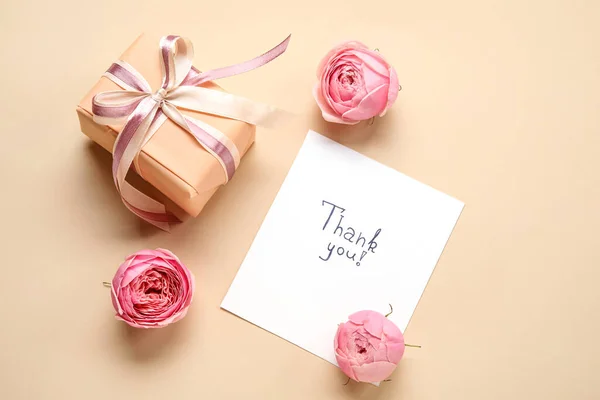 纸片上有文字谢谢你 礼品盒和米色背景的花朵 — 图库照片