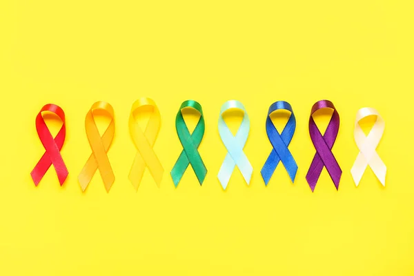 Sarı Arka Planda Renkli Farkındalık Şeritleri Dünya Kanser Günü — Stok fotoğraf