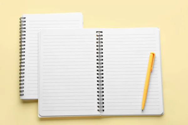 浅黄色背景的笔记本和钢笔 — 图库照片