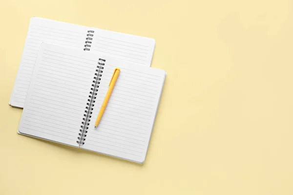 Σημειωματάρια Και Στυλό Ανοιχτό Κίτρινο Φόντο — Φωτογραφία Αρχείου