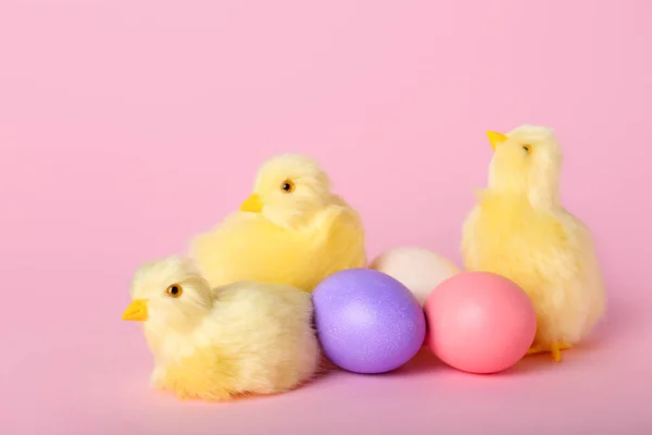 かわいい黄色の鶏とピンクの背景にイースターエッグ — ストック写真