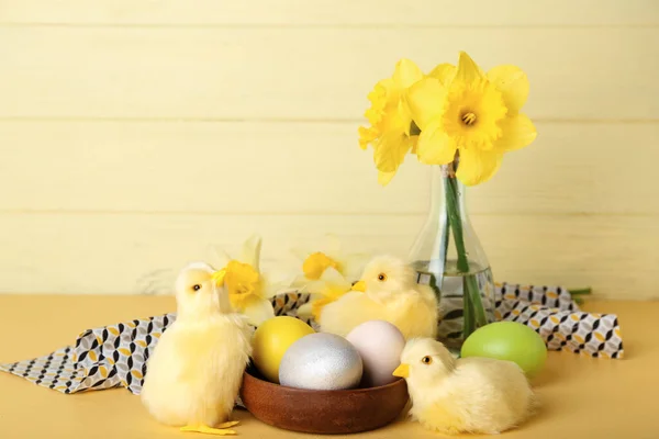 可爱的小鸡 复活节彩蛋和花朵放在桌上 — 图库照片