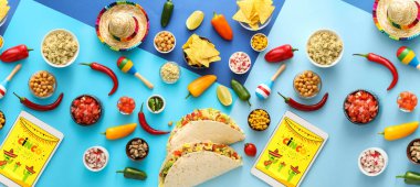Renkli arka planda geleneksel Meksika yemekleri ve tablet bilgisayarları. Cinco de Mayo (5 Mayıs) kutlamaları