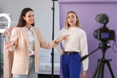 Genç bayan moda blogcuları stüdyoda video kaydediyor.