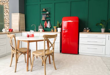 Modern mutfak, yemek masası, şık buzdolabı ve tezgahlar.