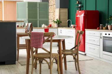 Mutfakta sandalyeleri olan şık bir yemek masası.