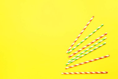 Sarı arka plandaki içecekler için şık pipetler