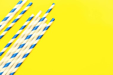 Sarı arka plandaki içecekler için şık pipetler