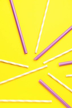 Sarı arka plandaki içecekler için şık pipetler