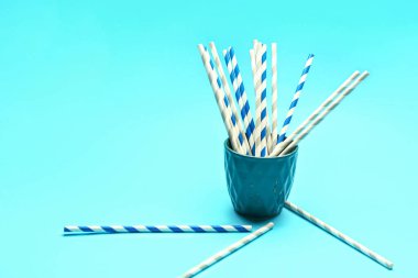 Mavi arka plandaki içecekler için şık pipetli kupa