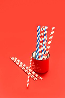 Kırmızı arka plandaki içecekler için şık pipetli kupa.