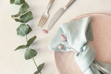 Işık arka planında şık masa dekorları, çiçekler ve okaliptüs dalları