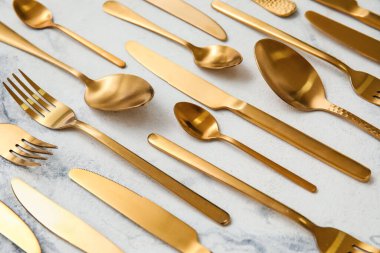 Açık mermer zemin üzerinde birçok farklı altın çatal bıçak