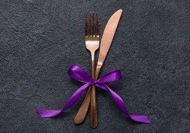 Koyu arkaplanda kurdeleli çatal ve bıçak