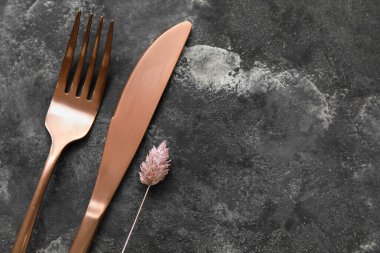 Grunge arka planında altın çatal bıçak takımı ve çiçek dekoru