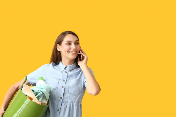 漂亮的女人 穿着绿色篮子里的衣服 用黄色背景的手机聊天 — 图库照片