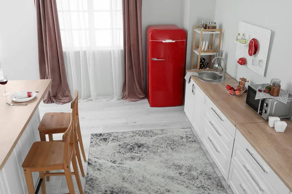 Interior Dapur Ringan Dengan Lemari Merah Meja Putih Dan Pegboard — Stok Foto