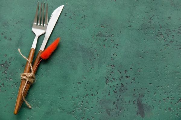 Yeşil arka planda çiçek dekoru olan çatal ve bıçak.