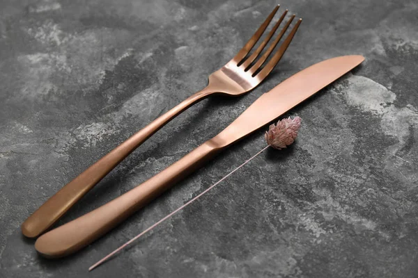 Grunge arka planında altın çatal bıçak takımı ve çiçek dekoru