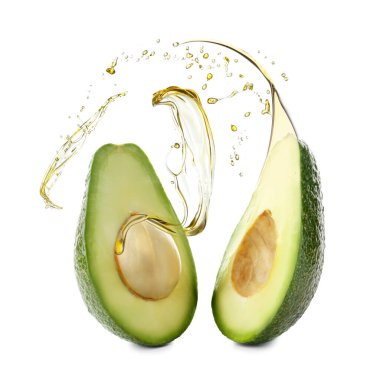 Beyaz arka planda yağ lekeleri olan olgun avokado yarıları.