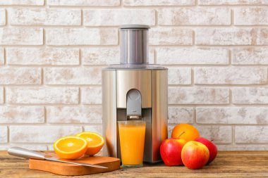 Yeni modern meyve sıkacağı ve bir bardak taze meyve suyu.